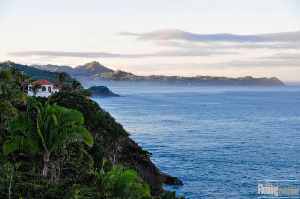 Peaceful sunrise, home perched on cliff, overlooking the Pacific Ocean in Mexico