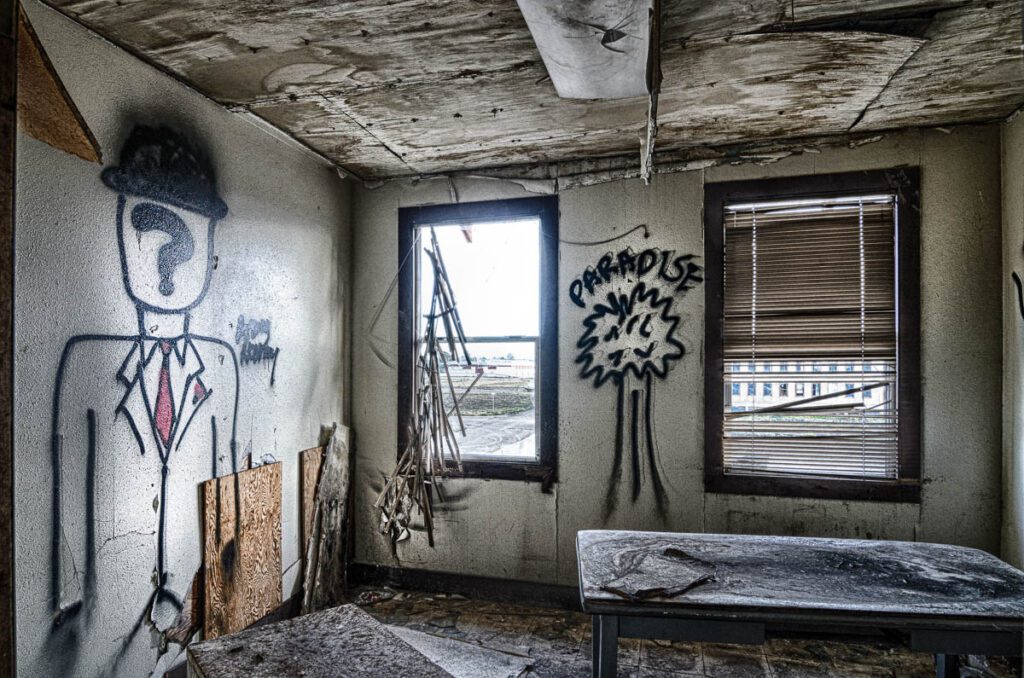 Decaying room of an abandoned building with debris and fallen ceiling.