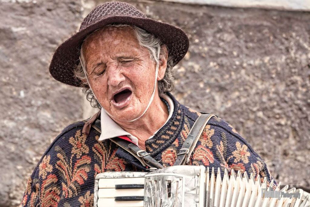 Blind woman street musician singing with accordion, Old Town Quito, Ecuador