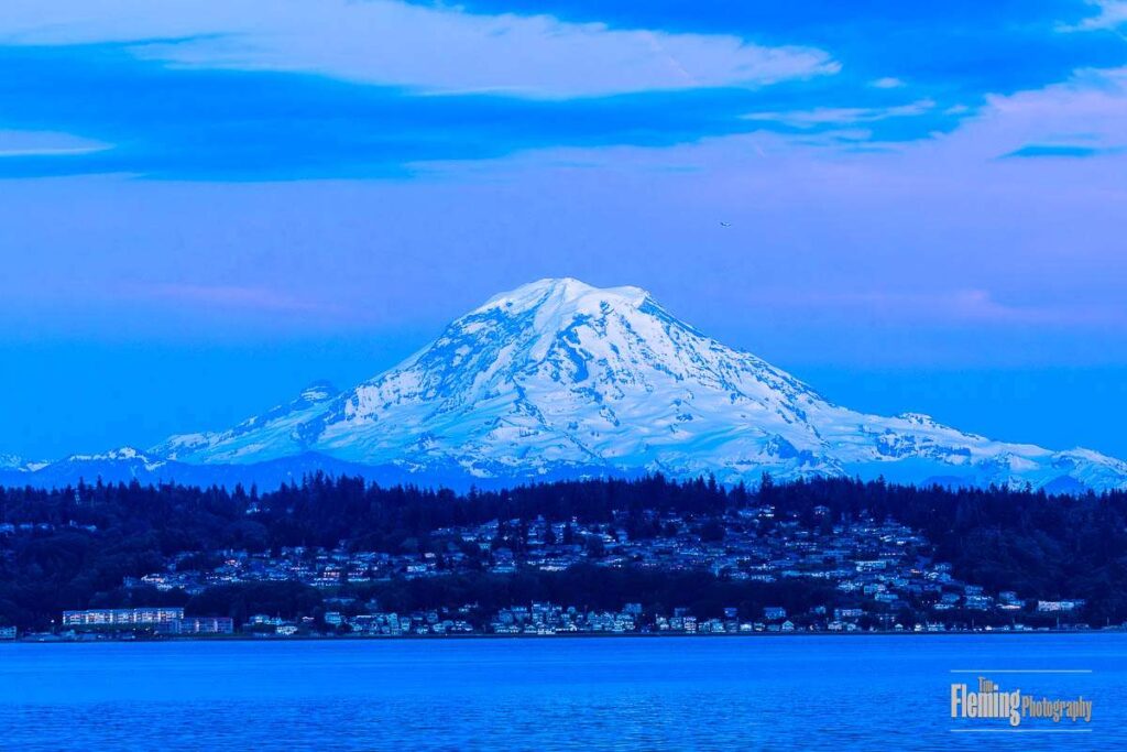 Mt Rainier, dusk, strong blue color, bay water and snowy peak
