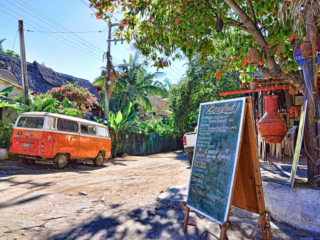 Vintage van parked on a street with storefronts and ambient city light.