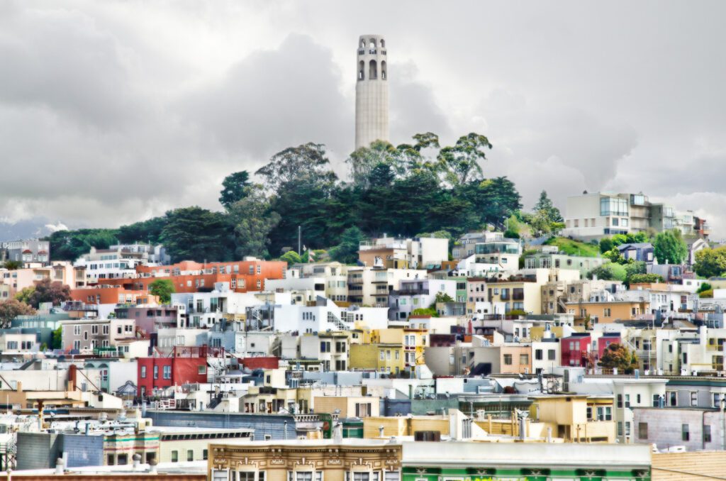 Coit Tower overlooking colorful houses in San Francisco.