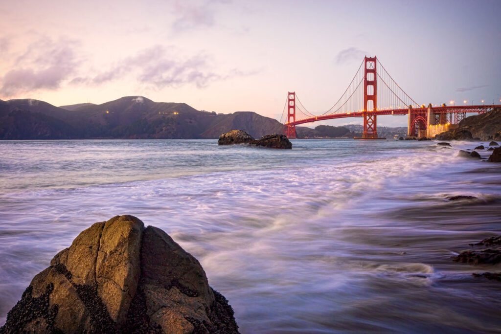 Golden Gate Bridge at dusk with ocean waves