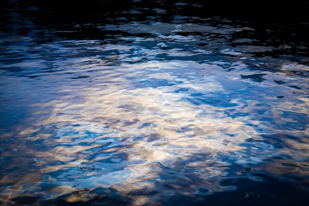 Close-up of light reflecting on rippling water surface.